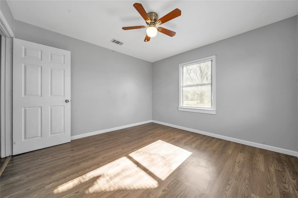 901 Johnson Street Terrell, TX 75160 - Photo 17 of 21 an empty room with wooden floor and windows
