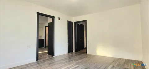 an empty room with wooden floor and closet