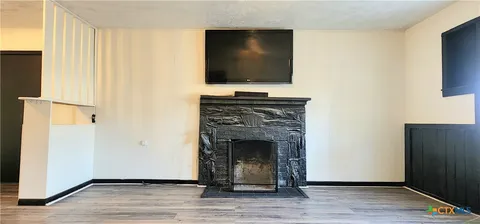 a living room with a fireplace and a flat screen tv