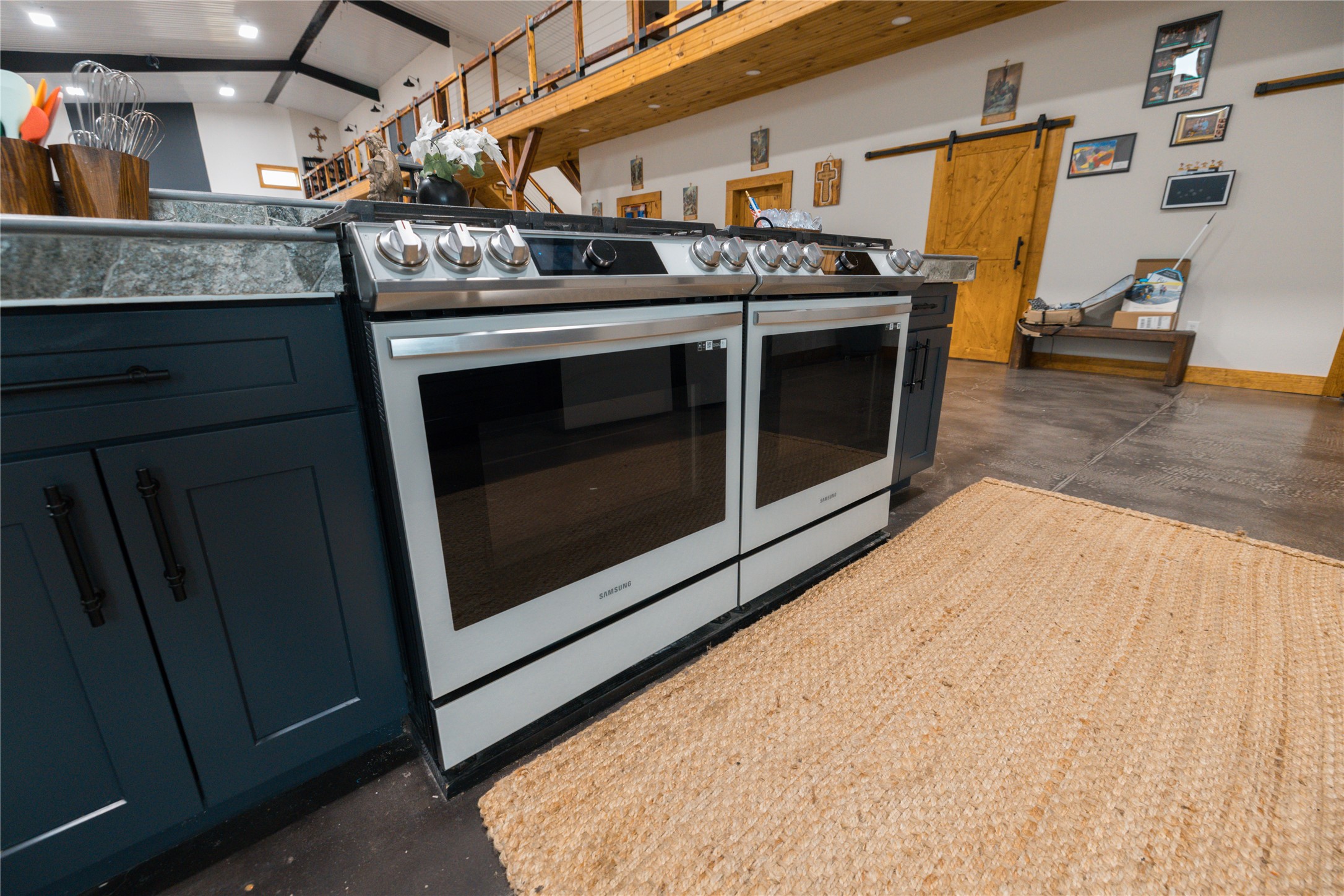 143 County Road Paige, TX 78659 - Photo 27 of 36 Kitchen with concrete floors, a barn door, and double stainless steel gas range