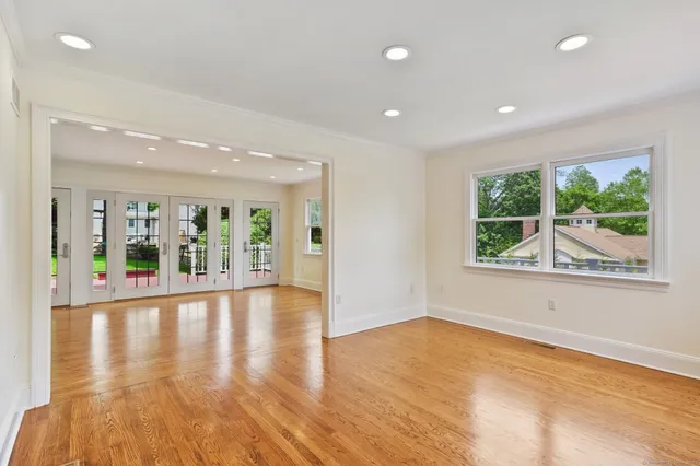 an empty room with wooden floor and outdoor view