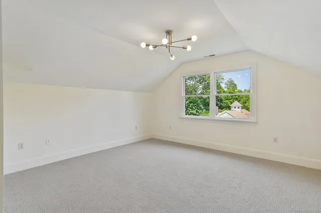 an empty room with windows and chandelier fan