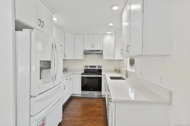 a kitchen with white cabinets and stainless steel appliances