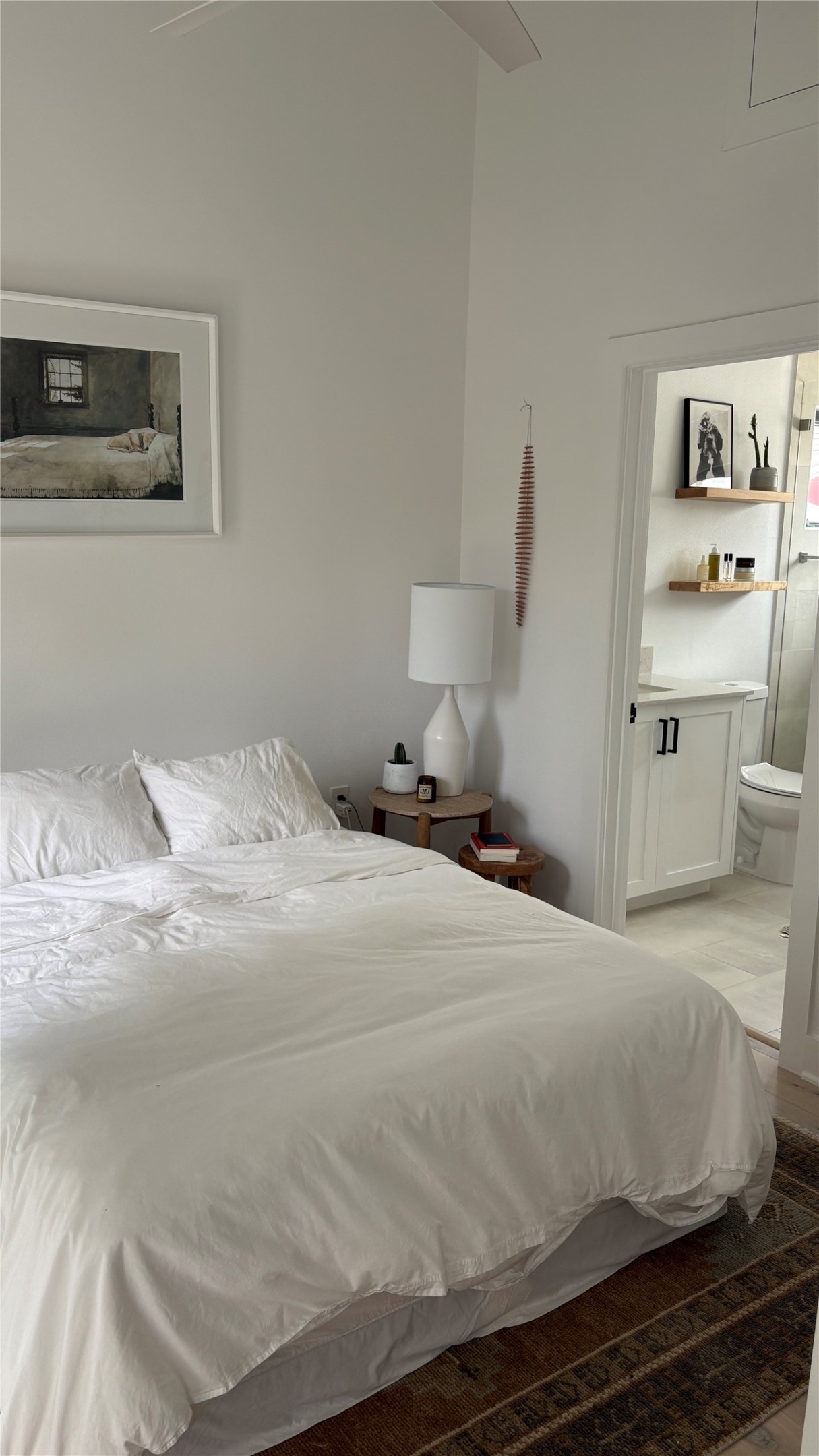 1816 Adina Street, Unit 2 Austin, TX 78721 - Photo 11 of 25 Vaulted ceiling with ceiling fan, wood-finish flooring, and a private ensuite bathroom featuring a vanity with dark hardware and open shelving
