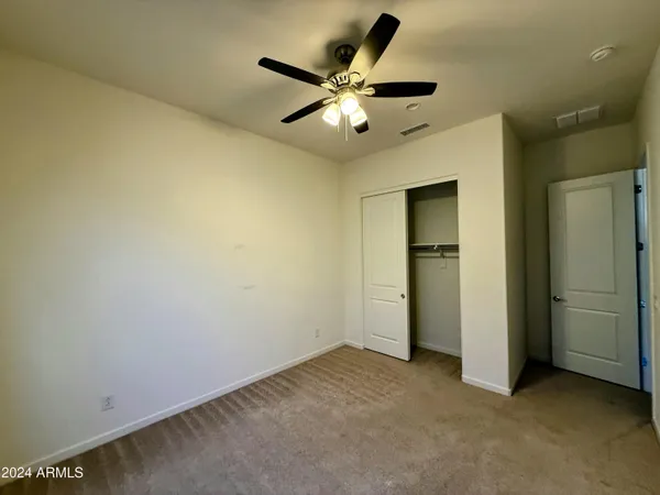an empty room with closet and windows