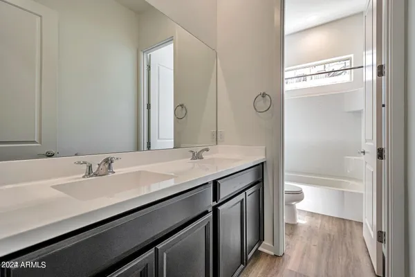 a bathroom with a sink a toilet and a large mirror