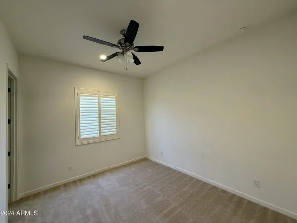 a view of a livingroom with a ceiling fan & windows