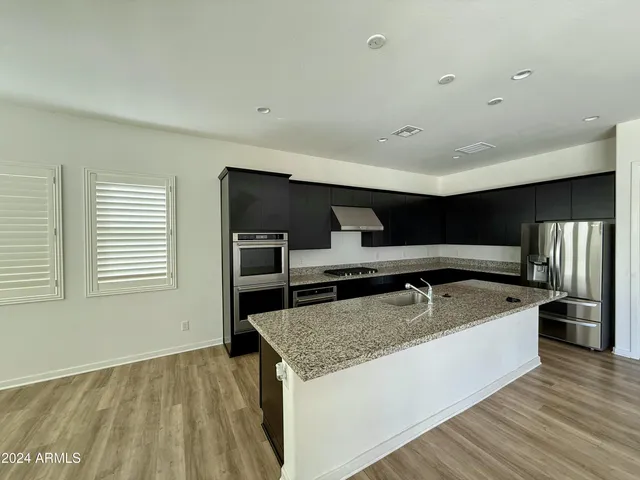 a living room with stainless steel appliances granite countertop furniture and a kitchen view