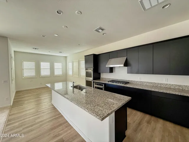 a large kitchen with kitchen island a sink stainless steel appliances and cabinets