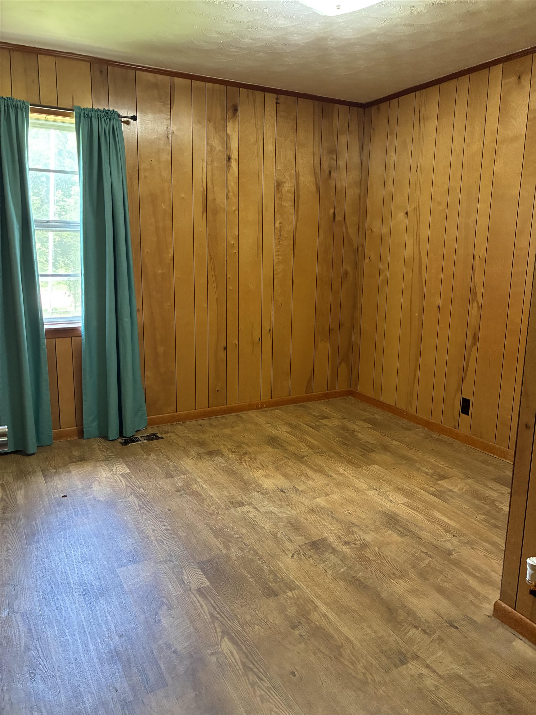 1421 Central Curve Road Ripley, TN 38063 - Photo 11 of 17 Unfurnished room featuring wood finished floors, wooden walls, and a textured ceiling