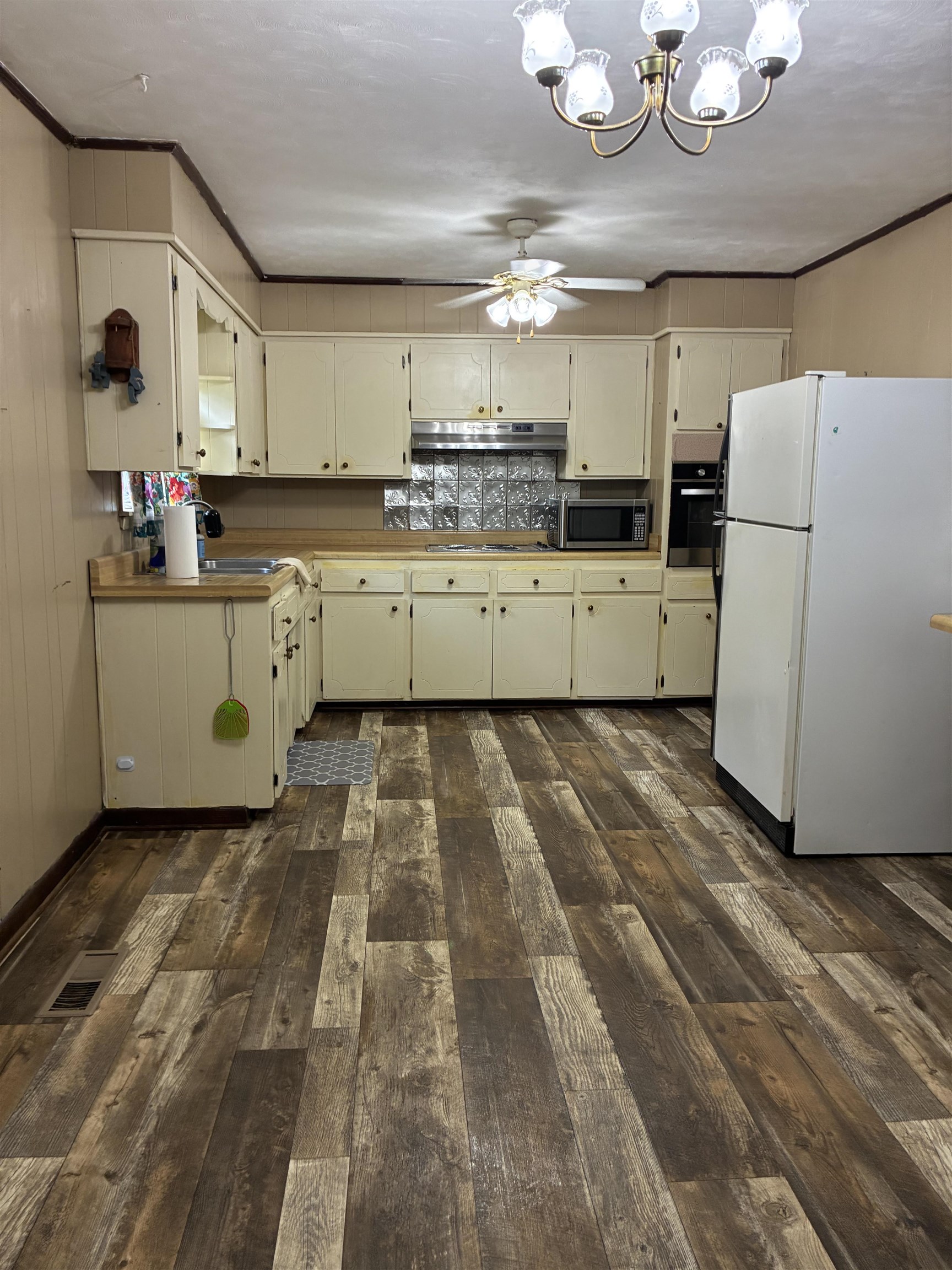 1421 Central Curve Road Ripley, TN 38063 - Photo 8 of 17 Kitchen with ornamental molding, stainless steel appliances, ceiling fan, a chandelier, and dark wood-type flooring