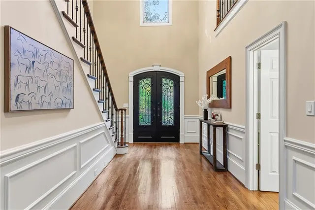 a view of a hallway with wooden floor and staircase