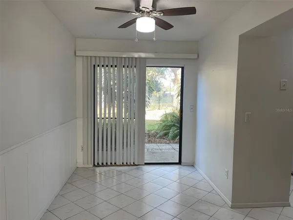 an empty room with fan and windows