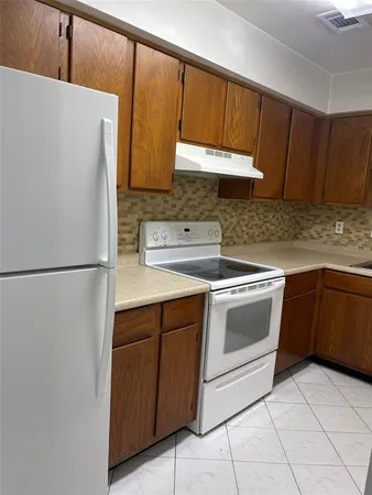 a kitchen with a refrigerator sink and cabinets