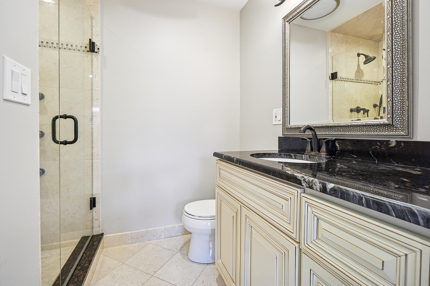 7039 Simpson Street Morton Grove, IL 60053 - Photo 11 of 24 a bathroom with a granite countertop sink a toilet a mirror and shower