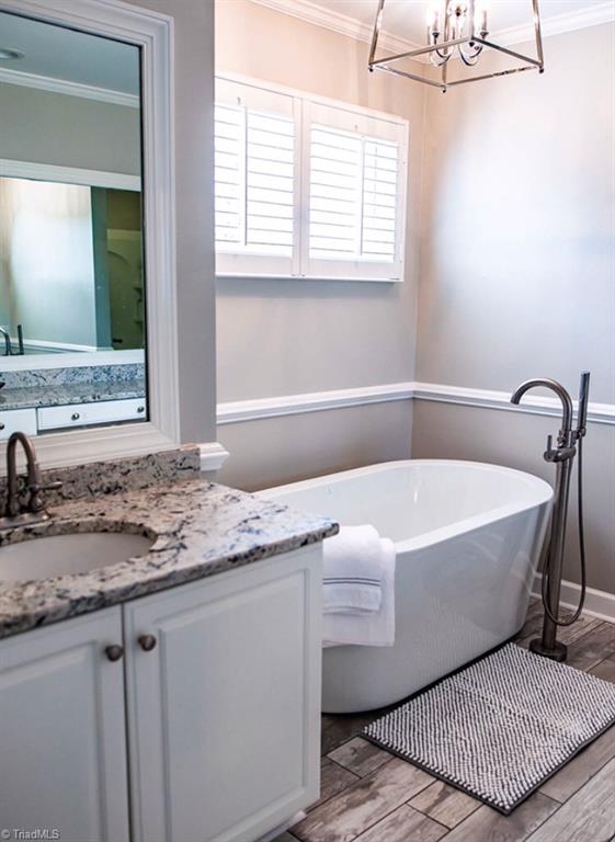 4901 Hackamore Road Greensboro, NC 27410 - Photo 14 of 21 Master bath features double sinks, soaking tub, separate shower and solid surface counters. Designer lighting brings a sophisticated ambiance to this calming spa-like bath.