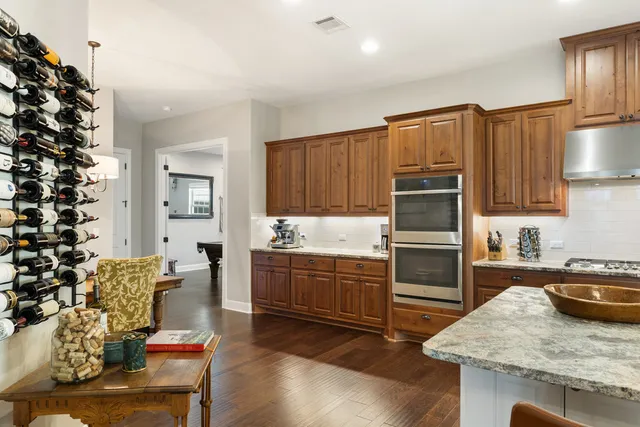 a kitchen with granite countertop kitchen island stainless steel appliances a stove a sink and a refrigerator