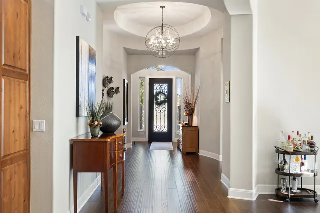 a view of a hallway with wooden floor and furniture