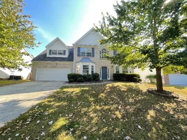 a front view of a house with a yard and garage