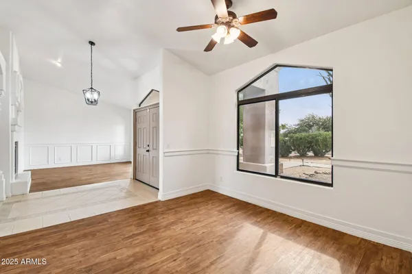 a view of an empty room with a window and wooden floor
