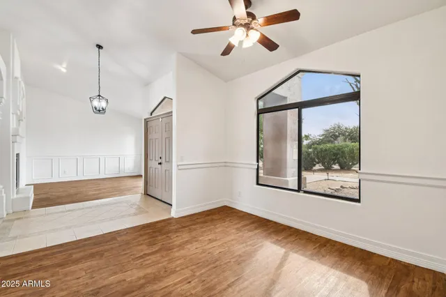 a view of an empty room with a window and wooden floor