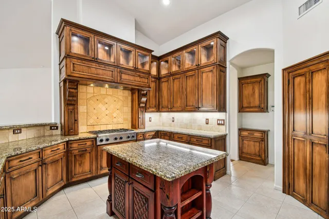 a kitchen with stainless steel appliances granite countertop a stove a sink and a wooden cabinets