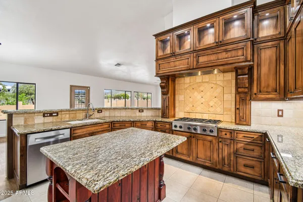 a kitchen with stainless steel appliances granite countertop a refrigerator stove and sink