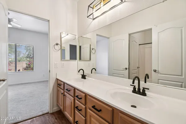 an empty room with wooden floor chandelier fan and windows