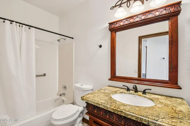 a bathroom with a sink a toilet a mirror and shower