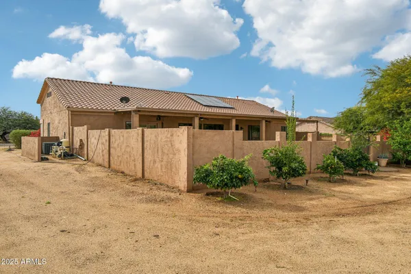 a front view of a house with swimming pool and furniture