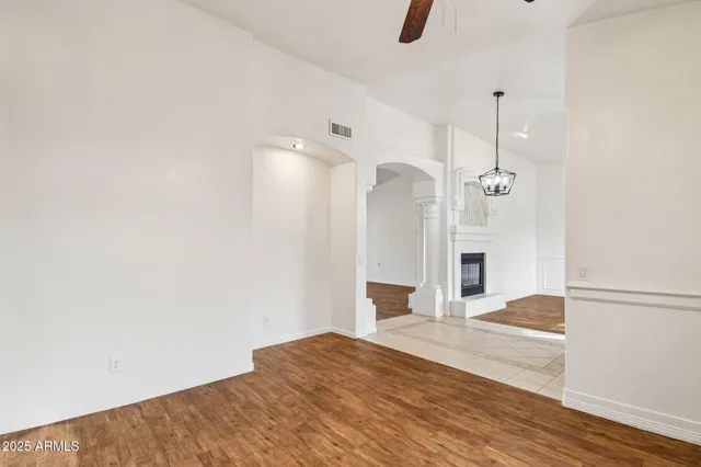 an empty room with a fireplace and wooden floor