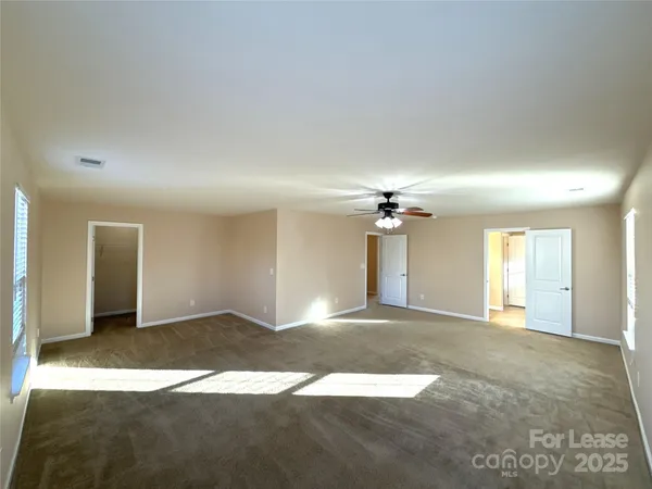 a view of a big room with a chandelier fan
