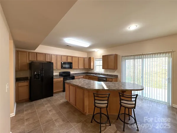 a kitchen with stainless steel appliances granite countertop a refrigerator and a stove top oven