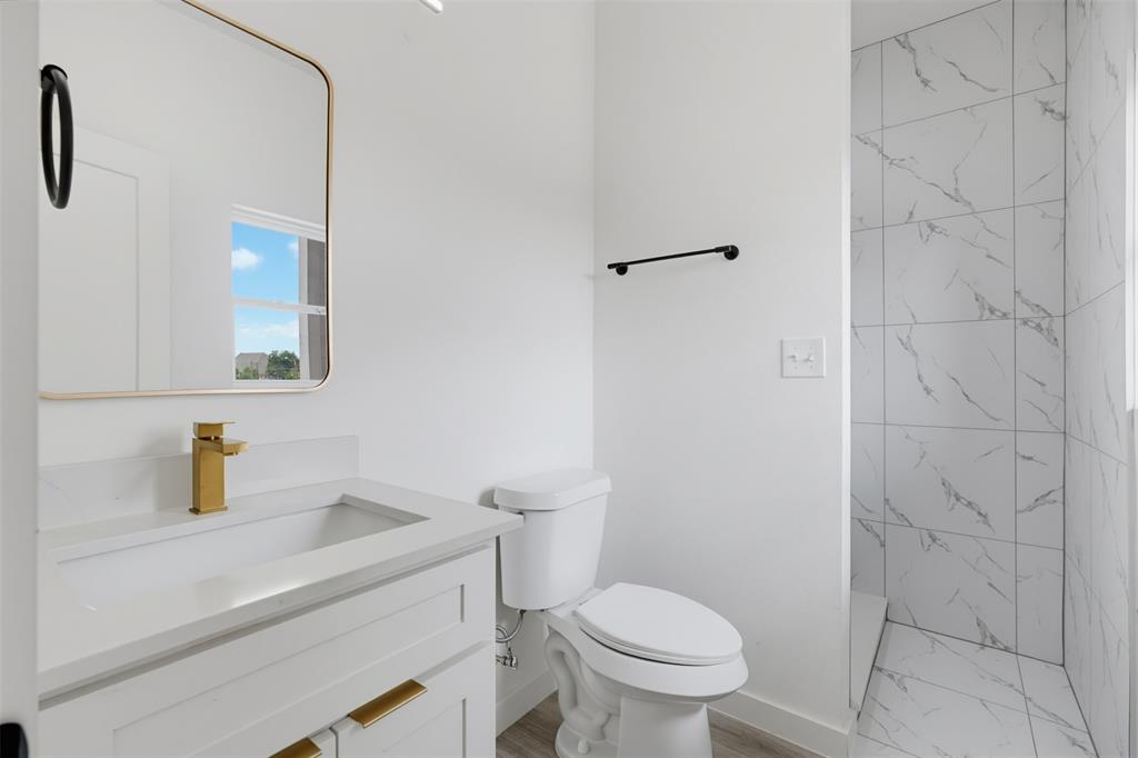516 South O Connor Road Irving, TX 75060 - Photo 20 of 23 Bathroom vanity featuring a gold-finish faucet and cabinet hardware