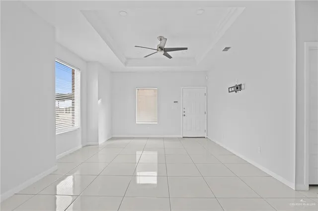 an empty room with windows and fan