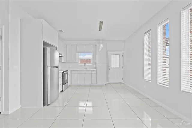 a view of a kitchen with refrigerator and windows