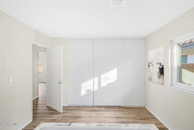 a bedroom with a bed and a painting on the wall