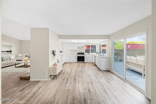 a view of a living room kitchen with furniture and wooden floor