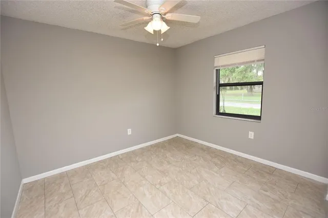 an empty room with a chandelier fan