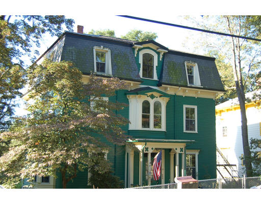a view of a brick house with large windows and a yard