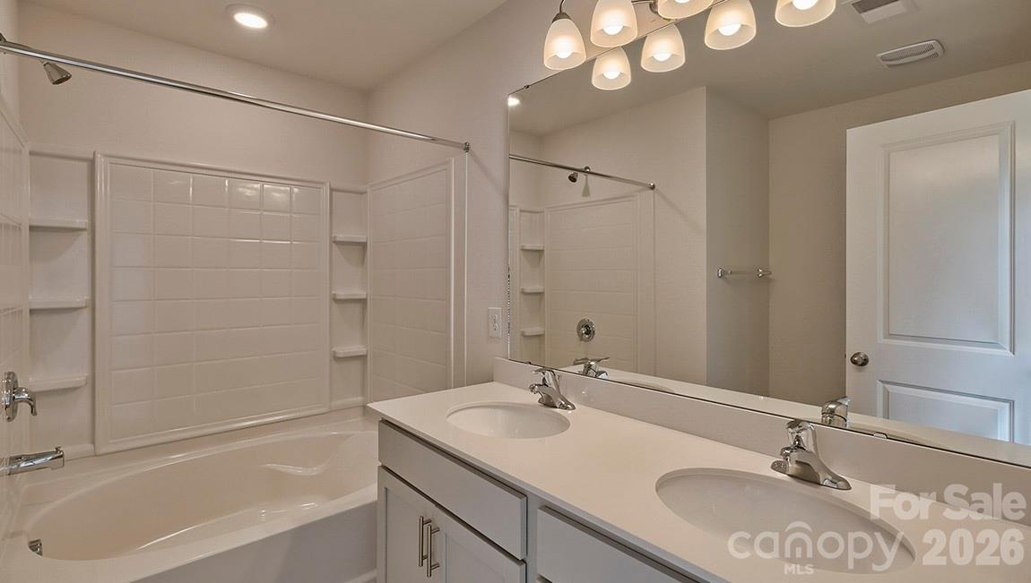 42 Salers Road Fletcher, NC 28732 - Photo 13 of 26 a bathroom with a granite countertop sink a mirror and a bathtub