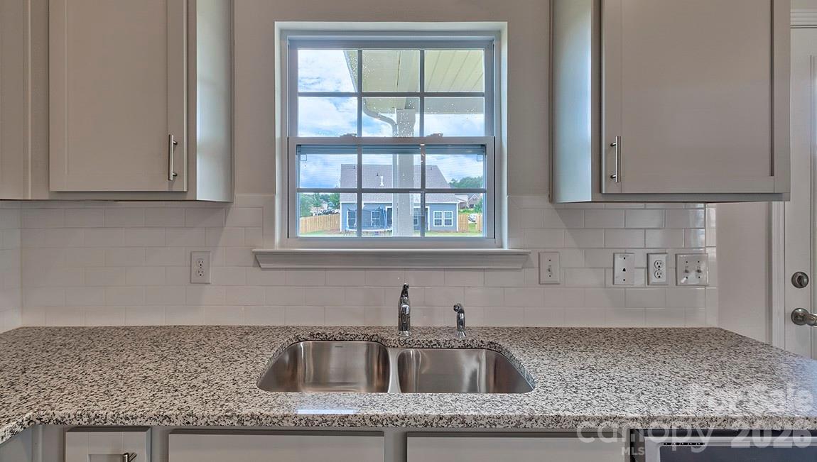42 Salers Road Fletcher, NC 28732 - Photo 10 of 26 a kitchen with granite countertop a sink window and cabinets