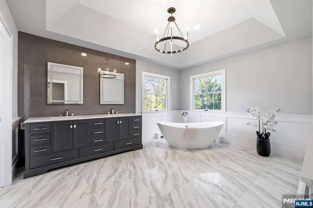 8 Wainwright Court Closter, NJ 07624 - Photo 13 of 29 a spacious bathroom with a double vanity sink a mirror and a bathtub