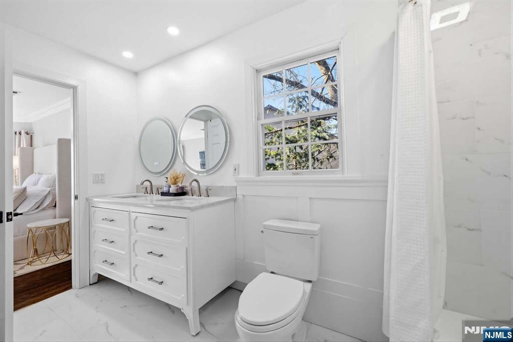 8 Wainwright Court Closter, NJ 07624 - Photo 17 of 29 a bathroom with a toilet a sink and mirror