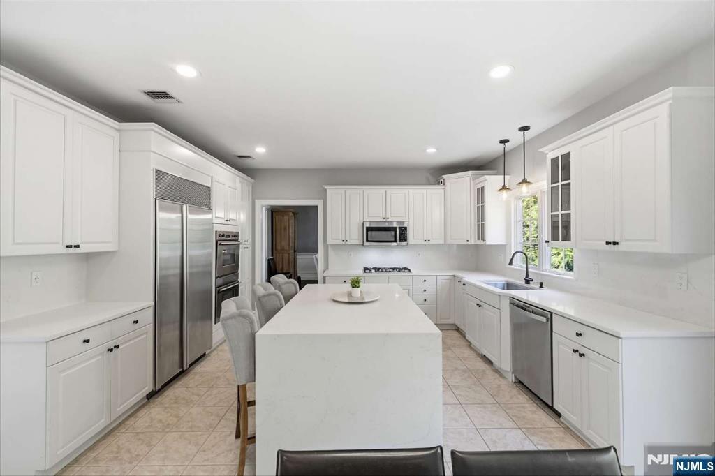 8 Wainwright Court Closter, NJ 07624 - Photo 5 of 29 a kitchen with sink refrigerator and cabinets