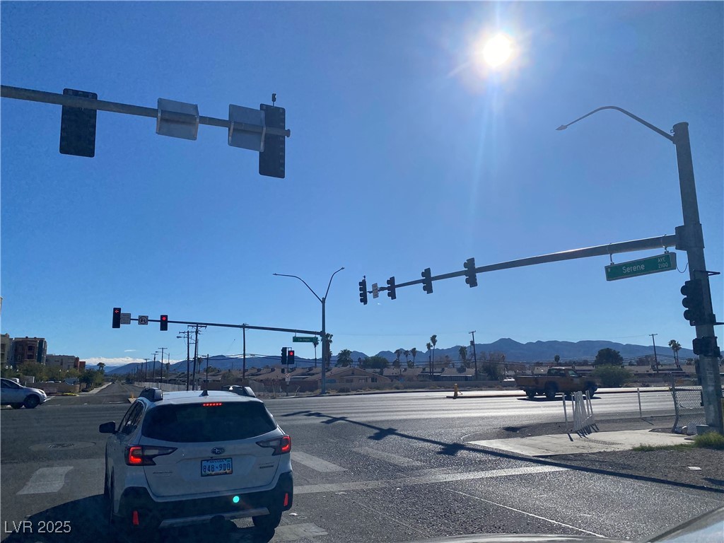 2405 West Serene Avenue, Unit 827 Las Vegas, NV 89123 - Photo 2 of 48 View of asphalt road featuring traffic lights, a mountain view, sidewalks, and street lights