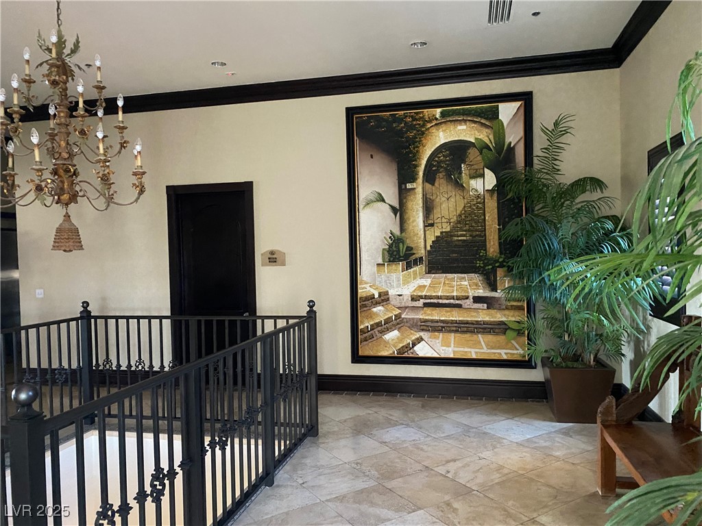2405 West Serene Avenue, Unit 827 Las Vegas, NV 89123 - Photo 24 of 48 Hall with ornamental molding, a chandelier, and an upstairs landing