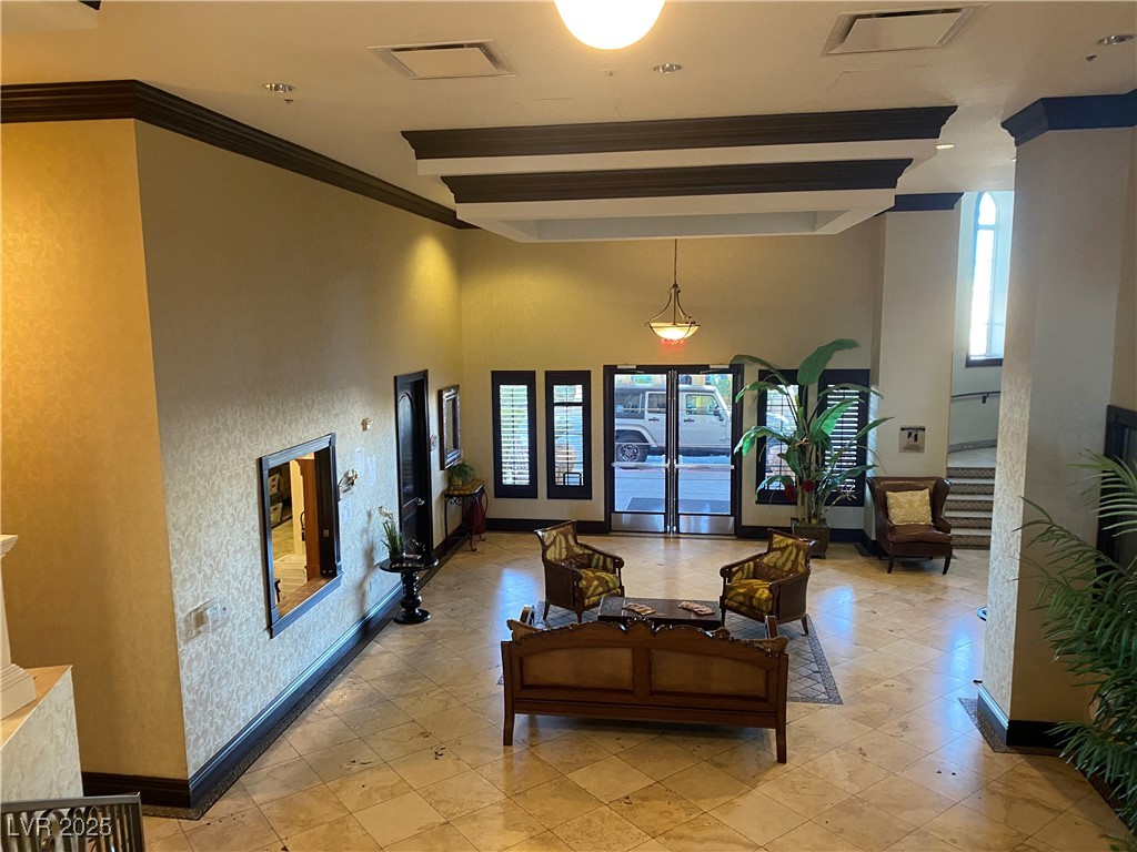 2405 West Serene Avenue, Unit 827 Las Vegas, NV 89123 - Photo 34 of 48 Living area with a towering ceiling, stairway, and ornamental molding