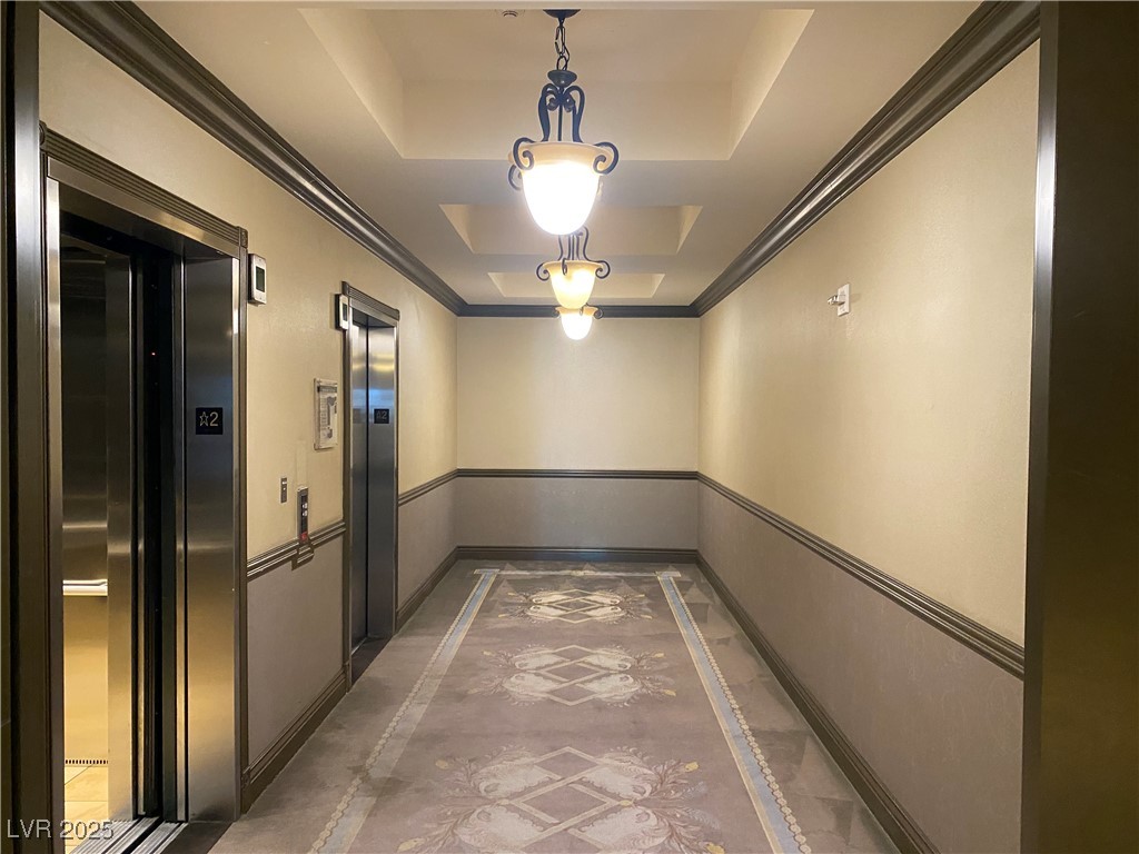 2405 West Serene Avenue, Unit 827 Las Vegas, NV 89123 - Photo 35 of 48 Elevator with inlaid floor details, a tray ceiling, and ornamental molding