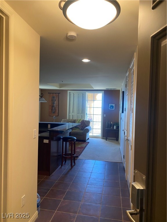 2405 West Serene Avenue, Unit 827 Las Vegas, NV 89123 - Photo 37 of 48 Corridor with dark tile patterned floors and dark colored carpet